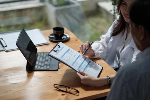 Two people doing paperwork and looking at a clipboard
